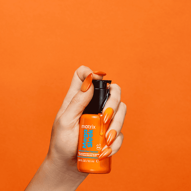 Treść wiadomości Gemini Dłoń trzymająca serum Matrix Mega Sleek na pomarańczowym tle, z kroplą produktu. Podpis: 'Krok 2 Rozprowadź równomiernie na włosach.'